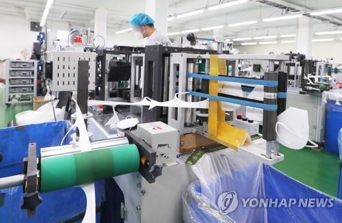 This file photo shows a mask production factory in Yongin, 50 kilometers south of Seoul, churning out face coverings used to help stem the spread of COVID-19. (Yonhap)