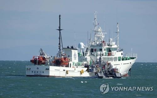 Officials from what appears to be a Coast Guard vessel conduct an on-site inspection of a South Korean fishery patrol vessel, anchored near the de facto inter-Korean sea border in the Yellow Sea, on Sept. 25, 2020. A Ministry of Oceans and Fisheries employee, who boarded the vessel, went missing on Sept. 21 while carrying out duties in waters off the western island of Yeonpyeong in the Yellow Sea and was killed by North Korean soldiers the following day. (Yonhap)