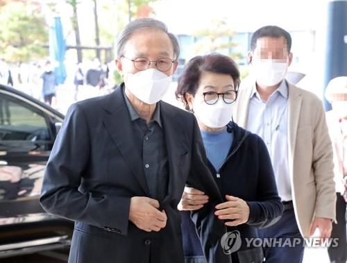 Former President Lee Myung-bak, helped by his wife, Kim Yoon-ok, arrives at Seoul National University Hospital in Seoul on Oct. 30, 2020, to see a doctor.(Yonhap)