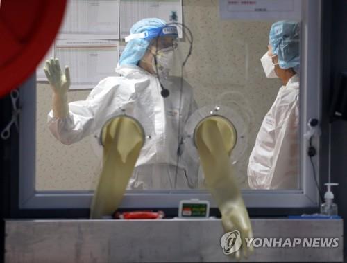 Medical workers prepare to conduct coronavirus tests at a makeshift clinic in Seoul on Jan. 11, 2021. (Yonhap) 