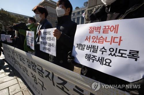 Associations of small businesses hold a press conference in front of the Constitutional Court, asking it to review whether virus-related restrictions violate their basic property rights, in Seoul on Feb. 24, 2021. (Yonhap)