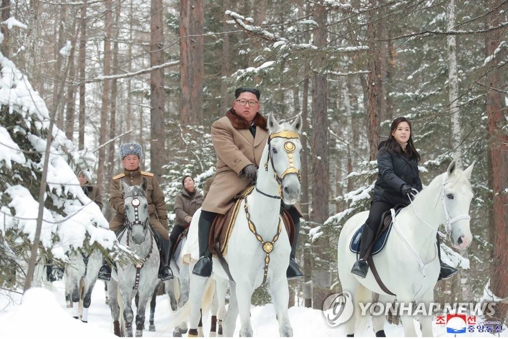 This photo, released by the Korean Central News Agency on Dec. 4, 2019, shows North Korean leader Kim Jong-un (C), alongside his wife, Ri Sol- ju (R), riding a white horse up a snow-covered Mount Paekdu, a volcano on the North Korean-Chinese border. Kim looked around revolutionary battle sites on the highest peak on the Korean Peninsula, considered sacred by Koreans. (For Use Only in the Republic of Korea. No Redistribution) (Yonhap)