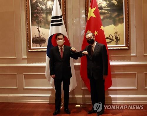 South Korean Foreign Minister Chung Eui-yong (L) and his Chinese counterpart, Wang Yi, bump elbows ahead of their talks in Xiamen, China, on April 3, 2021. (Yonhap)