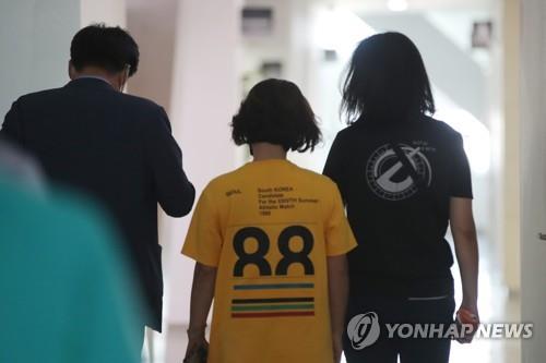 South Korean mountaineer Kim Hong-bin's wife (R) leaves a Gwangju City Hall office in charge of Kim's rescue operations on July 21, 2021. (Yonhap)