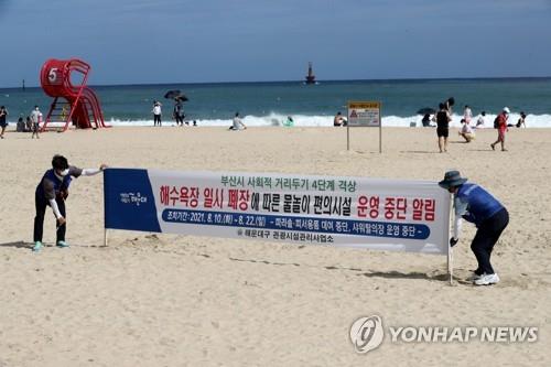 Busan city officials set up a banner on the closure of Haeundae Beach, one of South Korea's most popular summer destinations, in the southeastern port city on Aug. 10, 2021. (Yonhap) 
