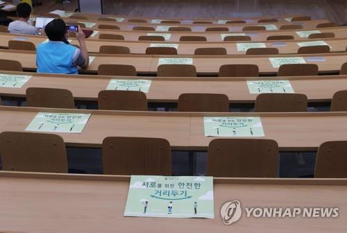 This photo taken Oct. 13, 2021, shows social distancing signs on tables at a lecture room at Seoul National University in Seoul. (Yonhap)