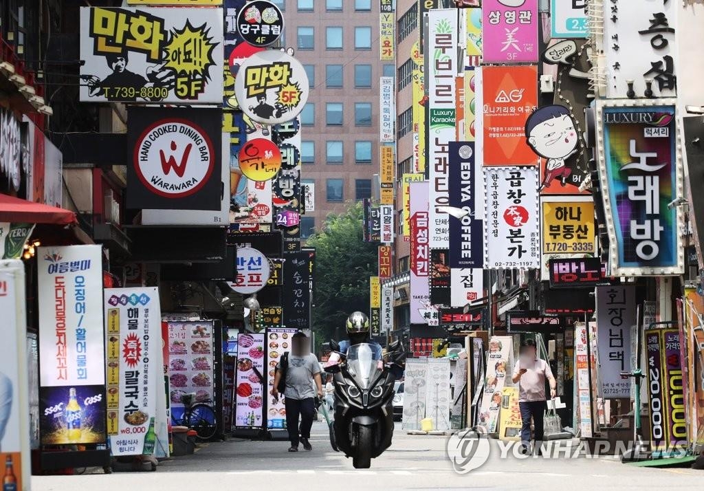 In this file photo, a delivery person departs from a restaurant to deliver lunch boxes to office workers at an empty food street in Seoul on July 12, 2021, as Level 4 social distancing was implemented amid the fourth wave of COVID-19. (Yonhap)