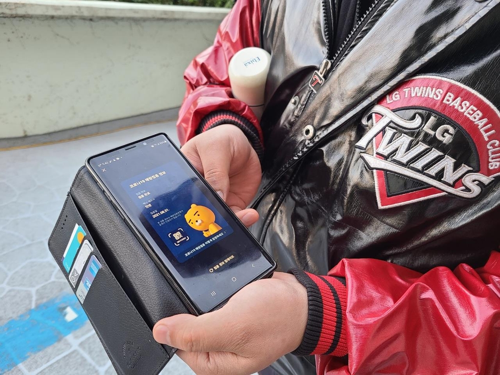 A fan of the Korea Baseball Organization (KBO) club LG Twins shows his proof of COVID-19 vaccination after arriving at Jamsil Baseball Stadium in Seoul on Oct. 19, 2021, for a KBO regular season game between the Twins and the Kiwoom Heroes. (Yonhap)