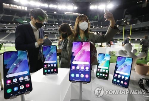 Reporters check out the Galaxy S21 FE in a media event held at Allegiant Stadium in Las Vegas on Jan. 4, 2022 (local time). (Yonhap)