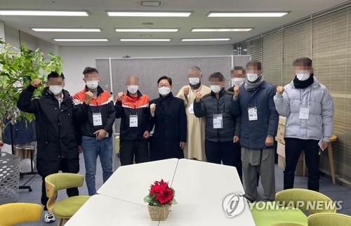 Justice Minister Park Beom-kye (4th from L) and seven Afghan evacuees who recently found jobs in South Korea pose for the camera, in this photo provided by the justice ministry on Jan. 3, 2022. (PHOTO NOT FOR SALE) (Yonhap)