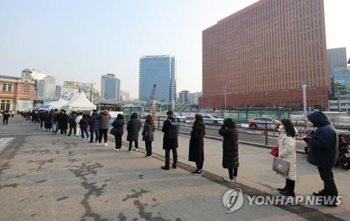 People wait in line to undergo COVID-19 tests at a makeshift testing station in Seoul on Feb. 25, 2022. (Yonhap) 