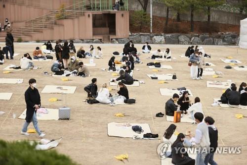 Students at Seoul's Sungkyunkwan University enjoy a spring festival on March 23, 2022, while maintaining social distancing. (Yonhap)