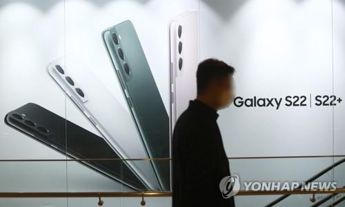 In the Feb. 14, 2022, file photo, a man walks past an advertisement for Galaxy S22 smartphones in Seoul. (Yonhap)