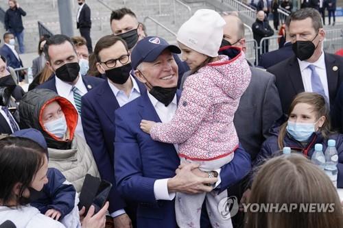 This AP file photo, issued on March 26, 2022, shows U.S. President Joe Biden meeting with Ukrainian refugees during a visit to PGE Narodowy Stadium in Warsaw. (PHOTO NOT FOR SALE) (Yonhap)