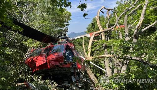 This image provided by firefighting authorities shows a crashed helicopter near the summit of Mt. Seonja in the southern coastal city of Geoje on May 16, 2022. (PHOTO NOT FOR SALE) (Yonhap)