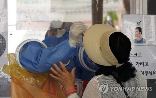 A medical worker conducts a COVID-19 test at a screening clinic in front of Seoul Station on June 13, 2022. (Yonhap)