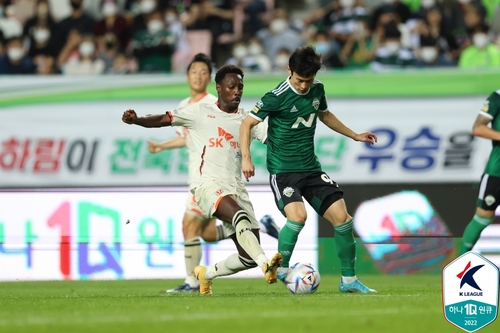 In this May 28, 2022, file photo provided by the Korea Professional Football League, Gerso Fernandes of Jeju United (L) and Kim Moon-hwan of Jeonbuk Hyundai Motors battle for the ball during the clubs' K League 1 match at Jeonju World Cup Stadium in Jeonju, 200 kilometers south of of Seoul. (PHOTO NOT FOR SALE) (Yonhap)