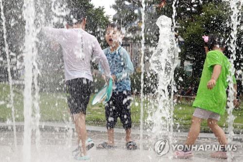 Children play in a fountain in the southern city of Jeonju on June 25, 2022, with the mercury rising above 30 C in many parts of the country. (Yonhap)