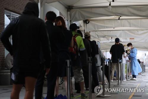 People wait to undergo COVID-19 tests at a testing station in Seoul on July 13, 2022. (Yonhap)