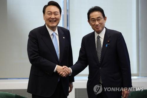 This file photo, taken Sept. 21, 2022, shows South Korean President Yoon Suk-yeol (L) shaking hands with Japanese Prime Minister Fumio Kishida ahead of their summit in New York. (Yonhap)