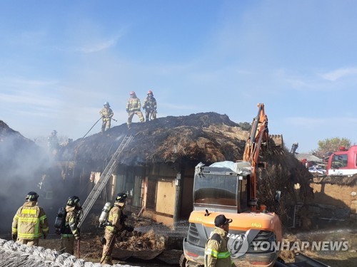 Firefighters put out a fire at a thatched house in Hahoe Village in Andong, 268 kilometers southeast of Seoul, on Nov. 4, 2022, in this photo provided by the local fire department. (PHOTO NOT FOR SALE) (Yonhap)