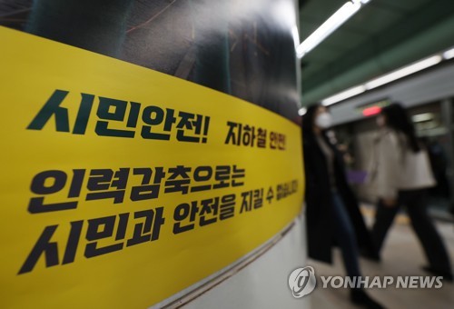 Commuters walk by a sign posted by unionized workers at Seoul Metro at Gwanghwamun Station in central Seoul on Nov. 29, 2022. (Yonhap)