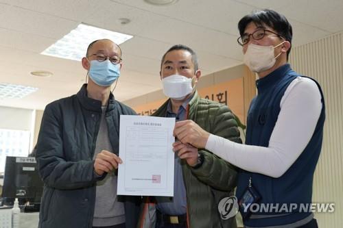 Peter Moller (C), co-head of the Danish Korean Rights Group, and South Korean adoptee activists pose with an application for an investigation into alleged rights violations of overseas adoptees at the Truth and Reconciliation Commission in Seoul on Nov. 15, 2022. (Yonhap)
