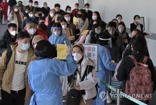 Quarantine officials introduce procedures for COVID-19 tests to entrants from China upon their arrival at Incheon International Airport, west of Seoul, on Jan. 2, 2023, when South Korea began to require a PCR test for all travelers from China as the virus rapidly spreads in the neighboring country. (Yonhap)