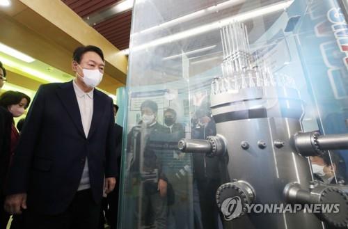 This file photo taken Nov. 29, 2021, shows Yoon Suk Yeol, then presidential candidate of the main opposition People Power Party, looking at a small modular reactor (SMR) during a visit to the Korea Atomic Energy Research Institute in Daejeon, 140 kilometers south of Seoul. (Yonhap)