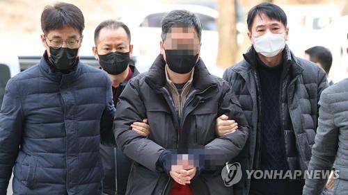 A South Korean activist (C) enters the Seoul Central District Court on Jan. 31, 2023, to attend a court hearing over his potential arrest. (Yonhap)