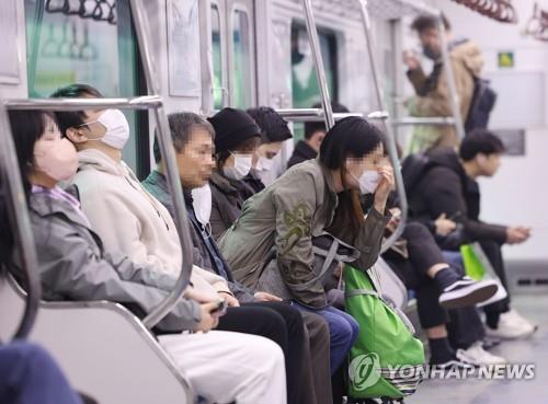 Most passengers remain masked up on a subway train in Seoul on March 20, 2023, the first day the mask mandate is lifted for public transportation. (Yonhap)