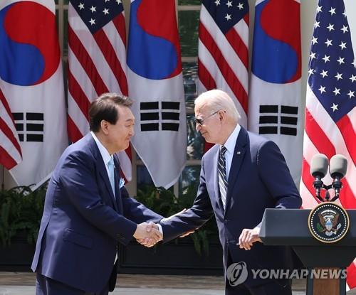 This file photo shows South Korean President Yoon Suk Yeol (L) shaking hands with U.S. President Joe Biden during a joint news conference after their summit at the White House in Washington, on April 26, 2023. (Yonhap)