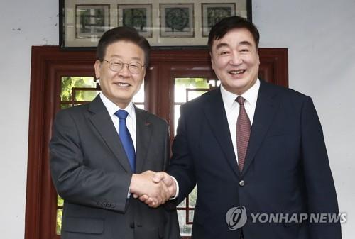 Lee Jae-myung (izquierda), líder del principal opositor Partido Democrático del país, le da la mano al embajador de China en Corea del Sur, Xing Haiming, en la residencia de este último en el centro de Seúl el 8 de junio de 2023. (Foto de grupo) (Yonhap)