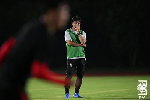 Hwang Sun-hong, head coach of the South Korean men's Asian Games football team, watches a training session at Zhejiang Jinhua No. 1 Middle School in Jinhua, China, on Sept. 17, 2023, in this photo provided by the Korea Football Association. (PHOTO NOT FOR SALE) (Yonhap)