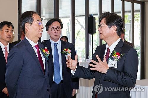 Prime Minister Han Duck-soo (L) speaks with Seong Ghi-hong, CEO and president of Yonhap News Agency, prior to the opening ceremony of a special photo exhibition celebrating the 70th anniversary of the South Korea-U.S. alliance in Seoul on Oct. 6, 2023. (Yonhap) 