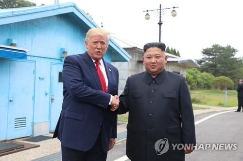 El presidente estadounidense Donald Trump (izq.) y el líder norcoreano Kim Jong-un se dan la mano en la aldea de Panmunjom, en la frontera intercoreana, el 30 de junio de 2019. (Yonhap)