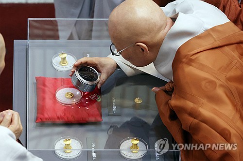 Ven. Jinwoo, president of the Jogye Order of Korean Buddhism, looks at "sarira" relics of Buddha during a Buddhist ceremony held at a museum on Korean Buddhist history and culture in central Seoul on April 19, 2024, to mark their return after 85 years in the Museum of Fine Arts, Boston. (Yonhap)