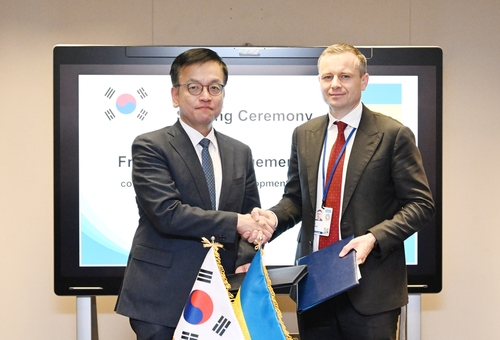 South Korean Finance Minister Choi Sang-mok (L) shakes hands with his Ukraine counterpart, Sergii Marchenko, after signing an agreement on low-interest loan programs for Ukraine in Washington on April 19, 2024, in this photo provided by South Korea's finance ministry. (PHOTO NOT FOR SALE) (Yonhap)