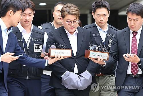 Popera star Kim Ho-joong is escorted by police officers from the Seoul Central District Court to wait in custody at the Gangnam Police Station on May 24, 2024, following a court hearing on an arrest warrant. (Yonhap) 