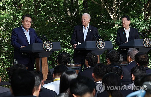 Esta foto del 18 de agosto de 2023 muestra al presidente surcoreano Yoon Suk Yeol (L), el presidente de los Estados Unidos, Joe Biden (C) y el primer ministro japonés Fumio Kishida, celebrando una conferencia de prensa conjunta sobre una reunión de la cumbre trilateral en el retiro presidencial Camp David en Maryland. (Yonhap)