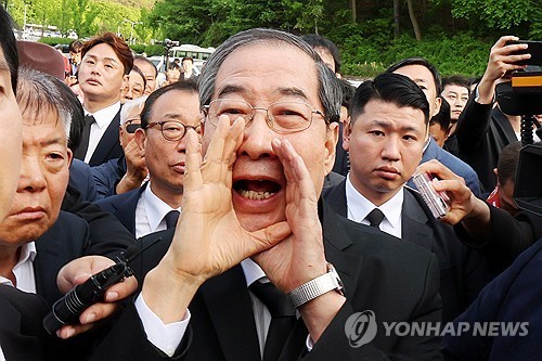 Former Prime Minister Han Duck-soo (C) makes a plea as he attempts to enter the May 18th National Cemetery in Gwangju, 357 kilometers south of Seoul, on May 2, 2025. (Yonhap)