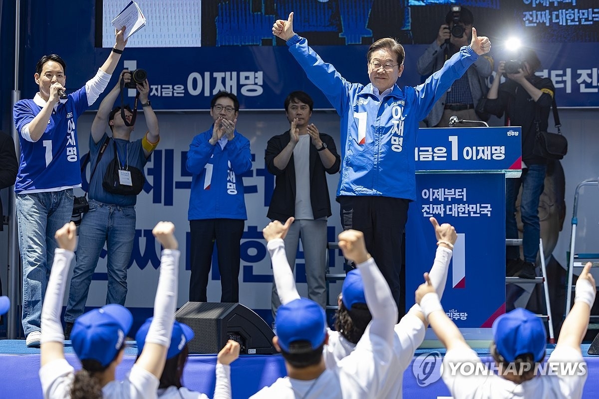 Democratic Party presidential candidate Lee Jae-myung (R) greets his supporters during a campaign rally in Busan, about 320 kilometers southeast of Seoul, on May 14, 2025. (Yonhap)