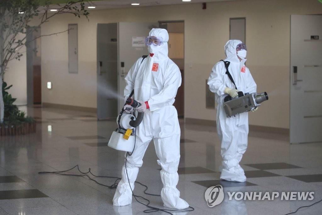 Des travailleurs sanitaires désinfectent le hall d'un centre de formation à Daejeon, le mercredi 9 juin 2021. 
