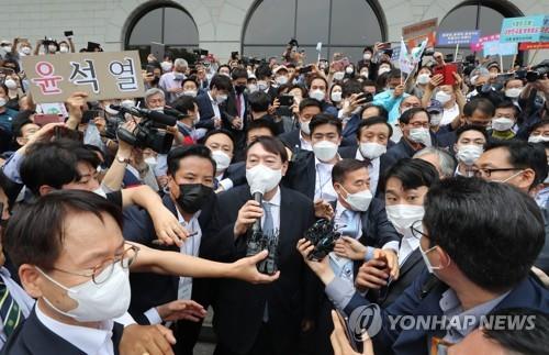 De fervents partisans applaudissent l'ex-procureur général Yoon Seok-youl alors qu'il quitte la salle commémorative Yun Bong-gil, un combattant de l'indépendance nationale, dans le sud de Séoul, après avoir annoncé sa candidature présidentielle, le 29 juin 2021.
