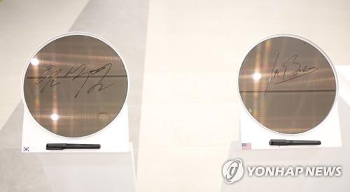 Les plaquettes de semi-conducteur signées par le président sud-coréen Yoon Suk-yeol (à g.) et le président américain Joe Biden (à dr.) dans une usine de puces Samsung Electronics à Pyeongtaek, à 70 kilomètres au sud de Séoul, le 20 mai 2022.