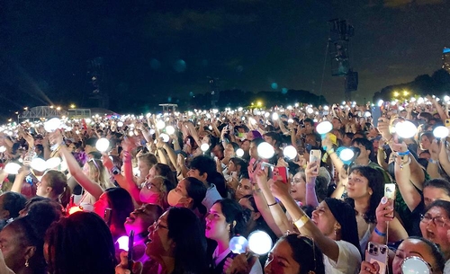 Les fans tenant Army Bomb, le batôn lumineux, devant la scène principale Bud Light Seltzer Stage du festival Lollapalooza se réjouissent de la performance de J-Hope, le dimanche 31 juillet 2022 (heure locale) à Chicago, aux Etats-Unis.