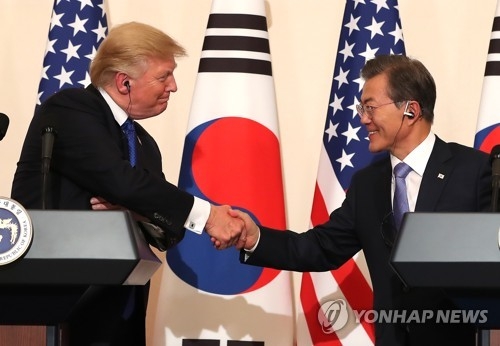 １１月７日の韓米首脳会談の後に行われた共同記者会見で握手を交わす文大統領（右）とトランプ大統領＝（聯合ニュース）