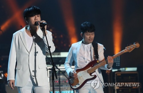 平壌公演で熱唱するユン・ドヒョン（左）＝（聯合ニュース）