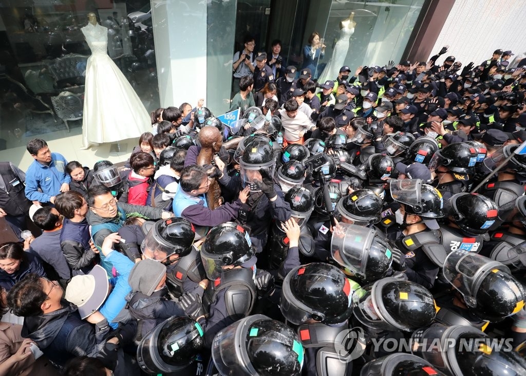 総領事館前に像を設置しようとして、警察ともみ合う団体のメンバー＝１日、釜山（聯合ニュース）