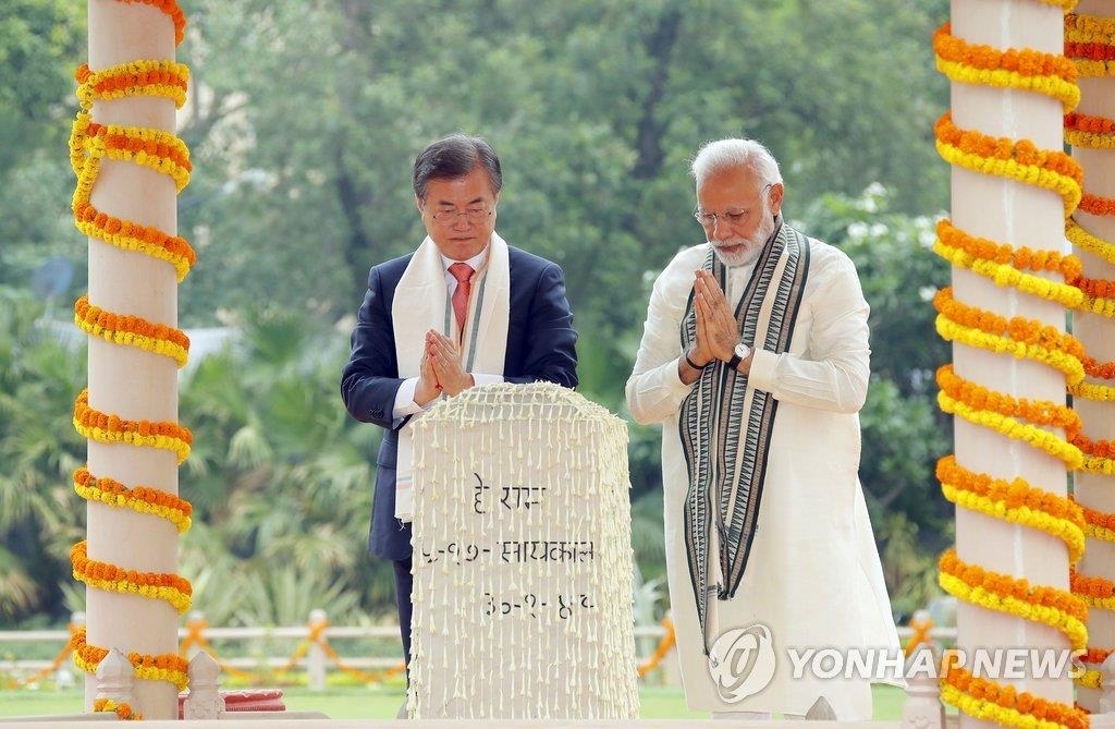 文大統領はインドのモディ首相とともにガンジー記念館を訪れた。記念碑の前で手を合わせる文大統領（左）とモディ首相＝９日、ニューデリー（聯合ニュース）